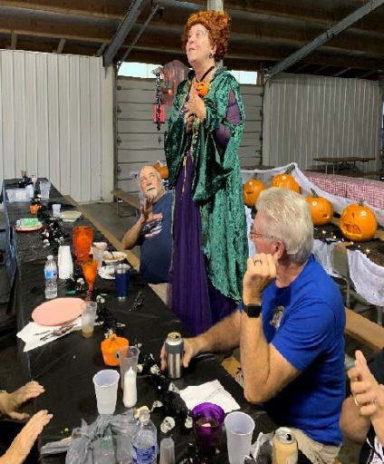 Woman in Halloween costume standing on a table.